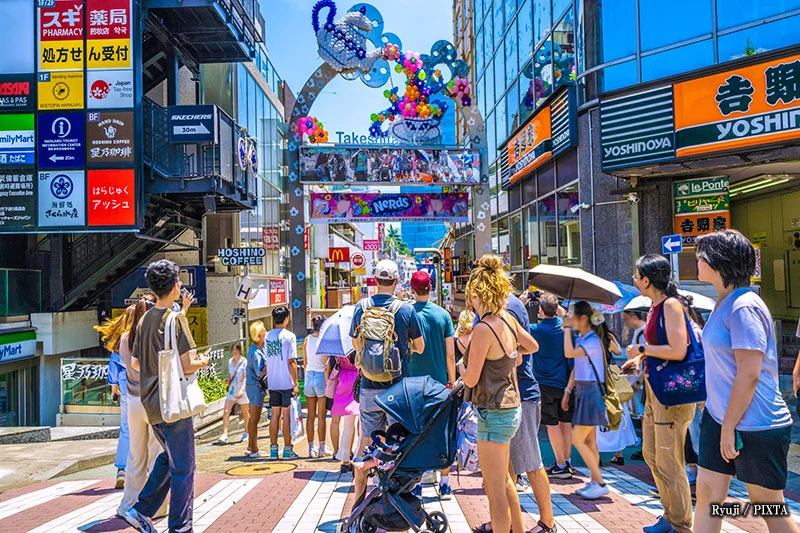 Crowds walking through Takeshita Street in Harajuku, Tokyo, a colorful and lively shopping street known for fashion boutiques, cafés, and youth culture.